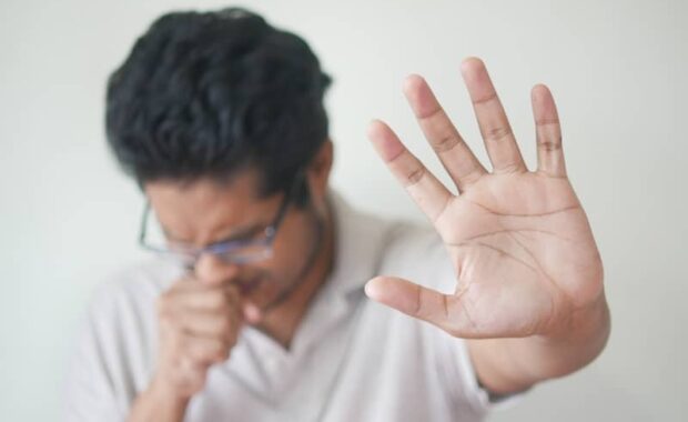 a man holding his hand up in front of his face